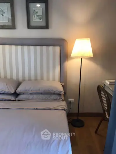 Cozy bedroom with elegant bed and stylish floor lamp