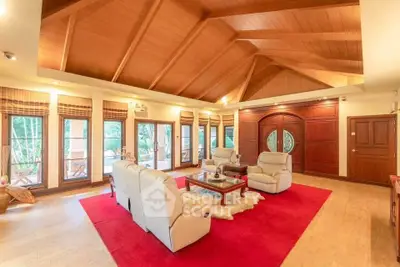 Luxurious living room with high wooden ceiling and elegant decor