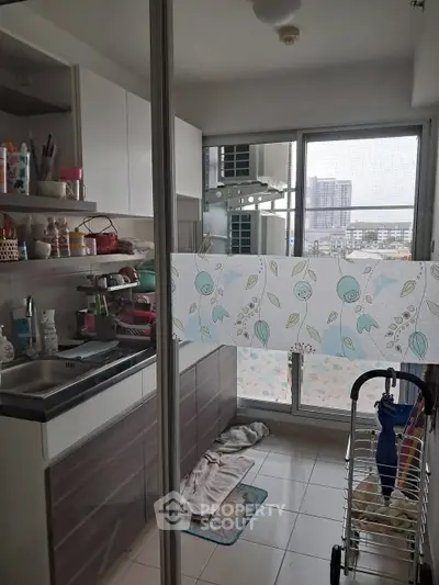 Compact kitchen with modern cabinets and city view from window