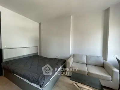 Modern bedroom with cozy bed and stylish sofa in a minimalist design.