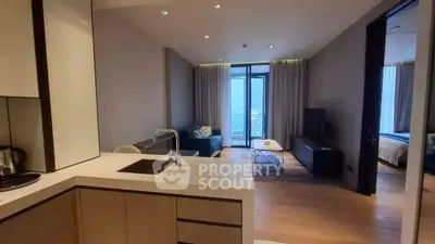 Modern open-plan living room with kitchen, featuring sleek design and balcony access.