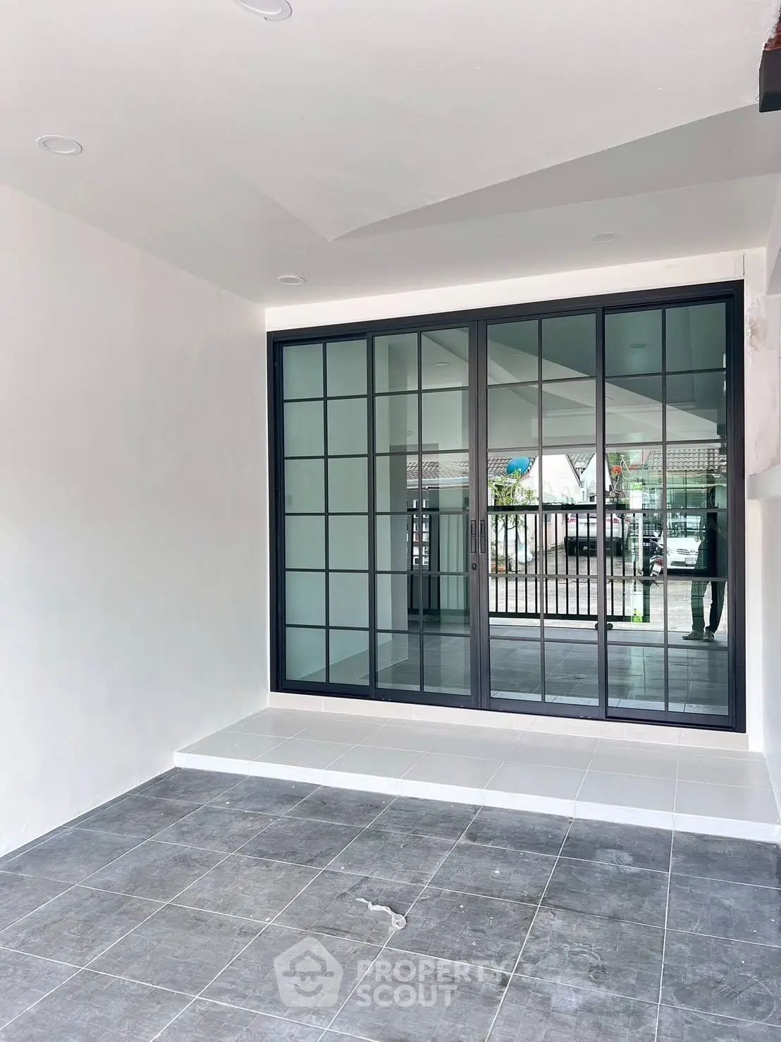 Modern minimalist entrance with sleek sliding glass doors and tiled flooring