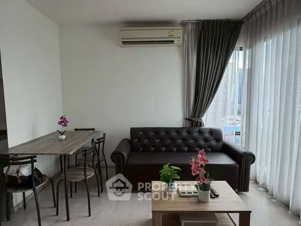 Modern living room with stylish sofa, dining table, and large windows for natural light.