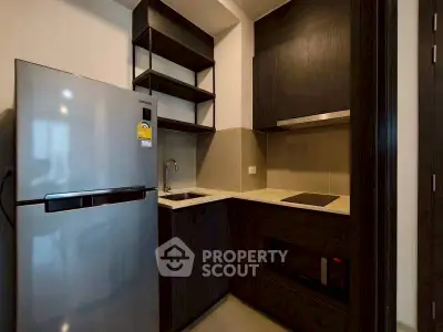 Modern compact kitchen with sleek appliances and dark cabinetry