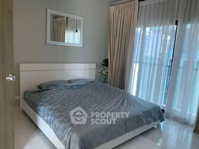 Modern bedroom with elegant decor and large window offering natural light