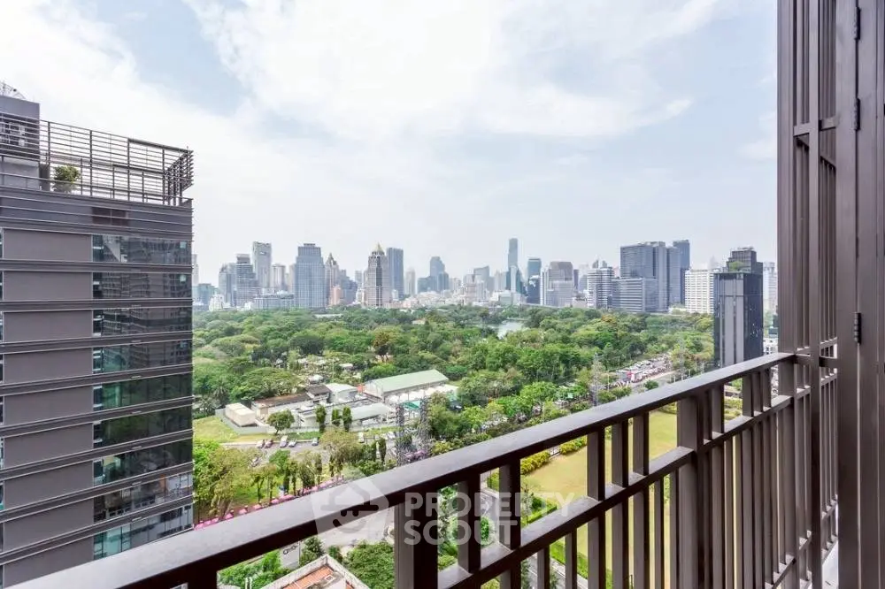 Stunning cityscape view from a high-rise balcony overlooking lush greenery and skyline.