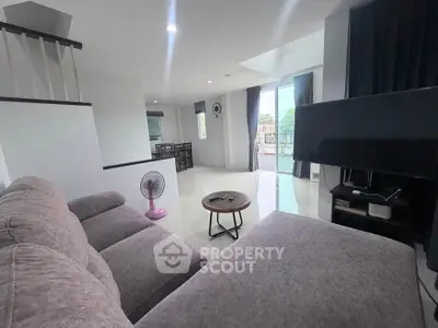 Spacious living room with modern decor and large windows offering natural light.