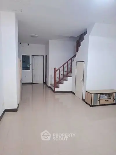 Spacious interior with staircase and modern flooring in a bright, open layout.