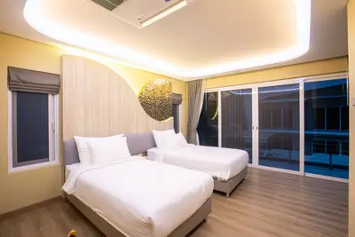 Modern bedroom with twin beds and stylish lighting in a contemporary apartment.