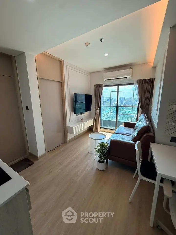 Modern living room with city view, featuring a cozy sofa and sleek decor.