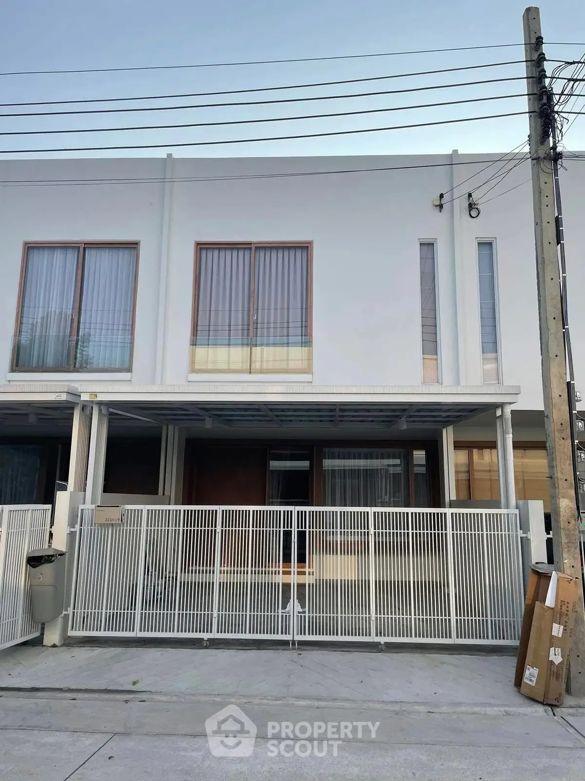 Modern townhouse exterior with sleek design and gated entrance in a suburban neighborhood.
