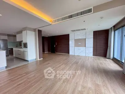 Spacious open-plan living room with modern kitchen and wooden flooring