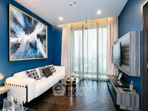 Modern living room with blue accent wall, large abstract painting, and floor-to-ceiling windows.