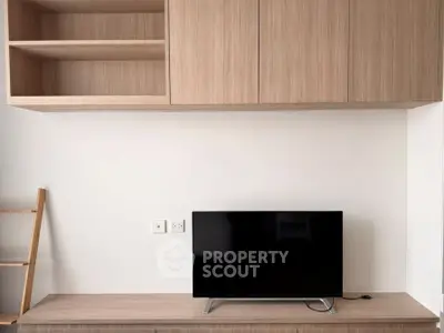 Modern living room with sleek wooden cabinetry and flat-screen TV, perfect for minimalist design enthusiasts.