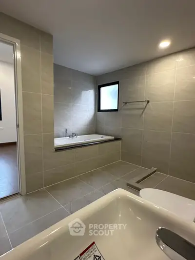 Spacious modern bathroom with bathtub and sleek tile design