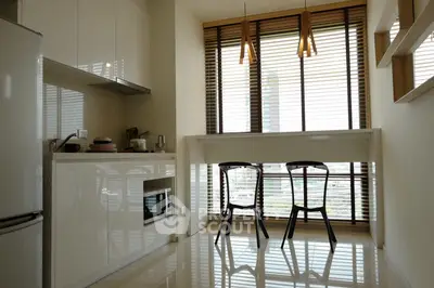Modern kitchen with sleek design and large windows offering natural light.
