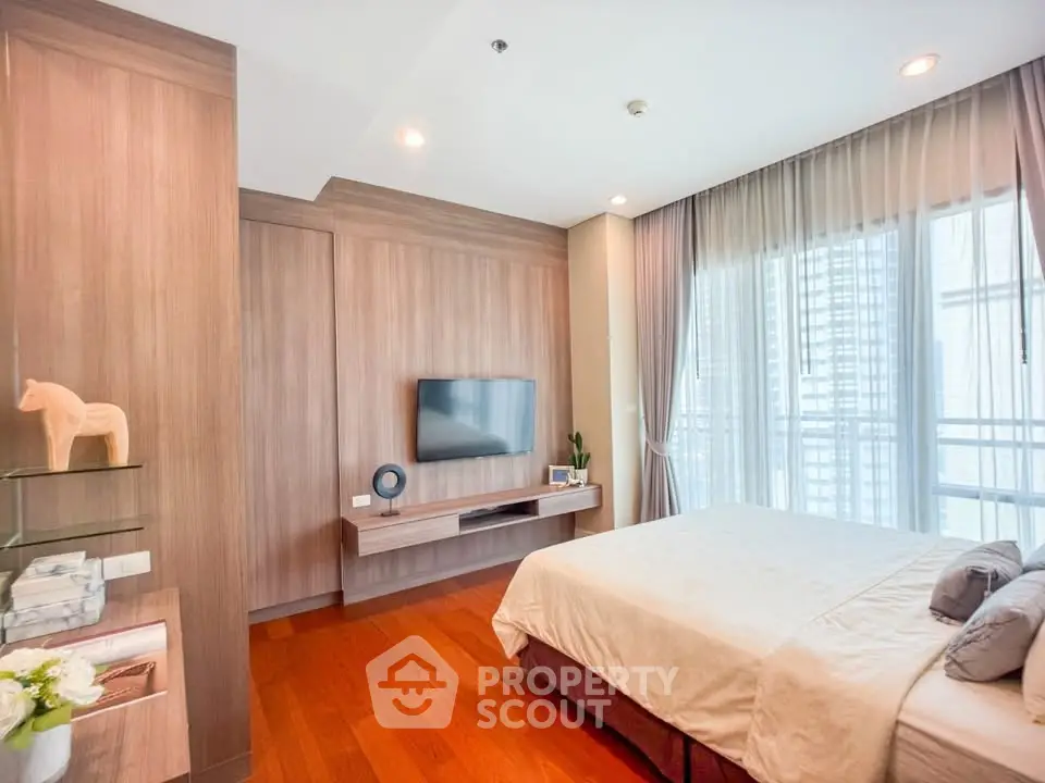 Luxurious bedroom with modern decor and large windows offering city views