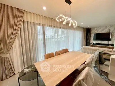 Modern dining area with elegant lighting and large windows in a stylish home.