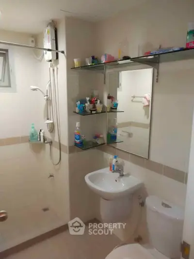 Modern bathroom with shower, sink, and mirror in a cozy apartment.
