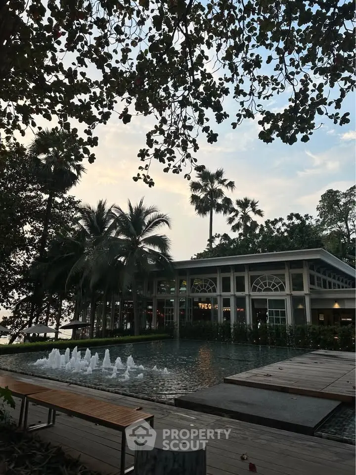 Stunning exterior view of a modern building with lush greenery and a serene water feature.