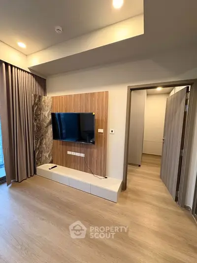 Modern living room with sleek TV setup and wooden flooring, perfect for contemporary living.