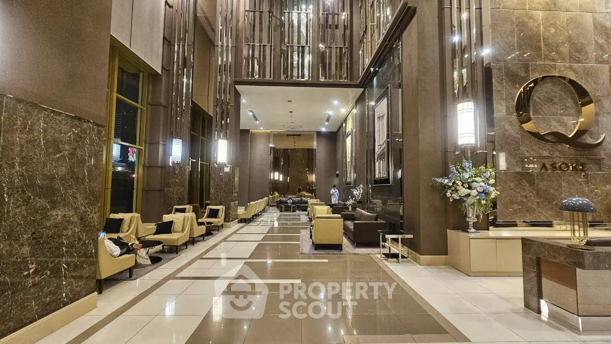 Luxurious high-ceiling lobby with elegant seating and modern decor in upscale building.