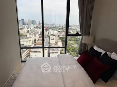 Luxurious bedroom with stunning city view from floor-to-ceiling windows in modern high-rise apartment.