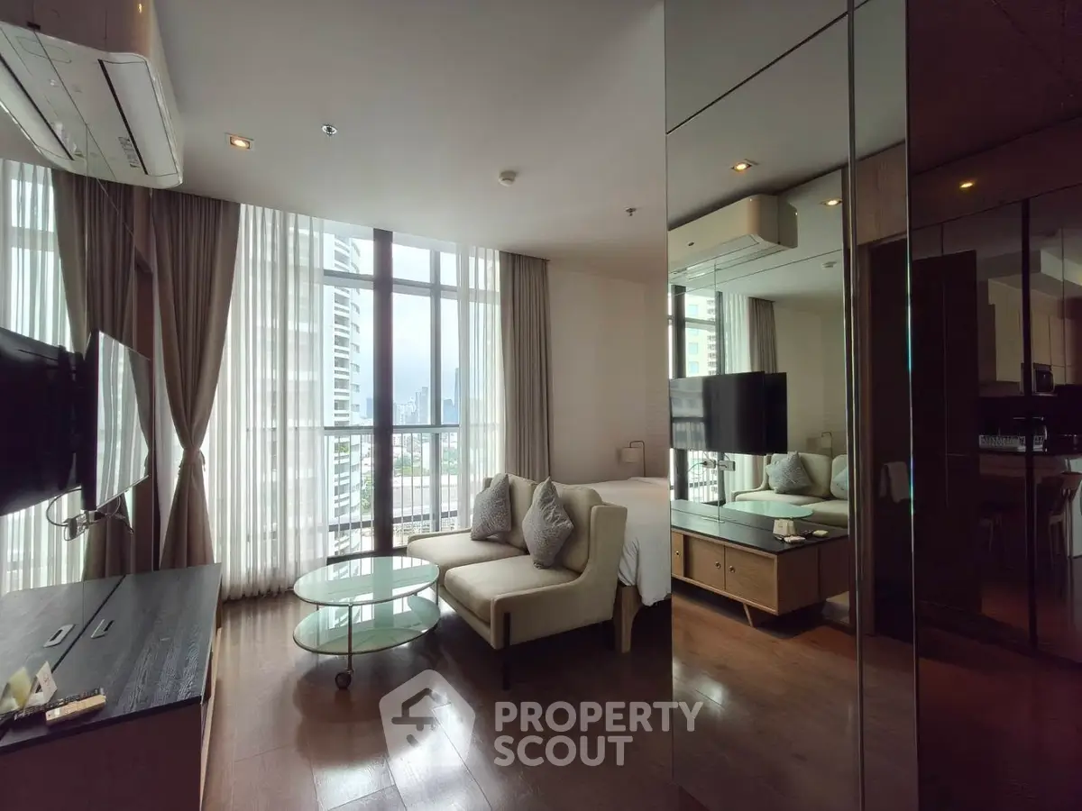 Luxurious modern living room with floor-to-ceiling windows and elegant furnishings in a high-rise apartment.