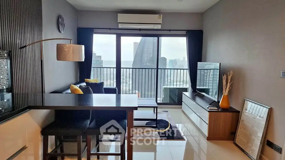 Modern living room with city view, sleek furniture, and large windows in a high-rise apartment.