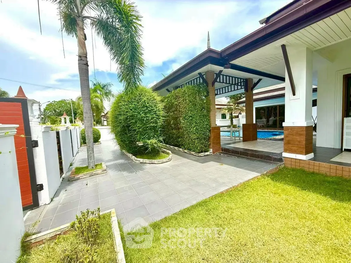 Charming villa with lush garden and poolside patio, perfect for outdoor relaxation.