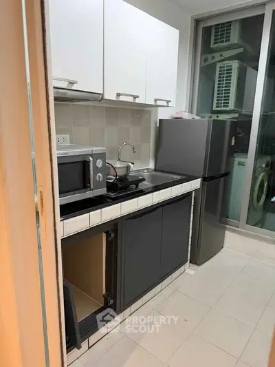 Modern kitchen with sleek appliances and ample storage in a stylish apartment.