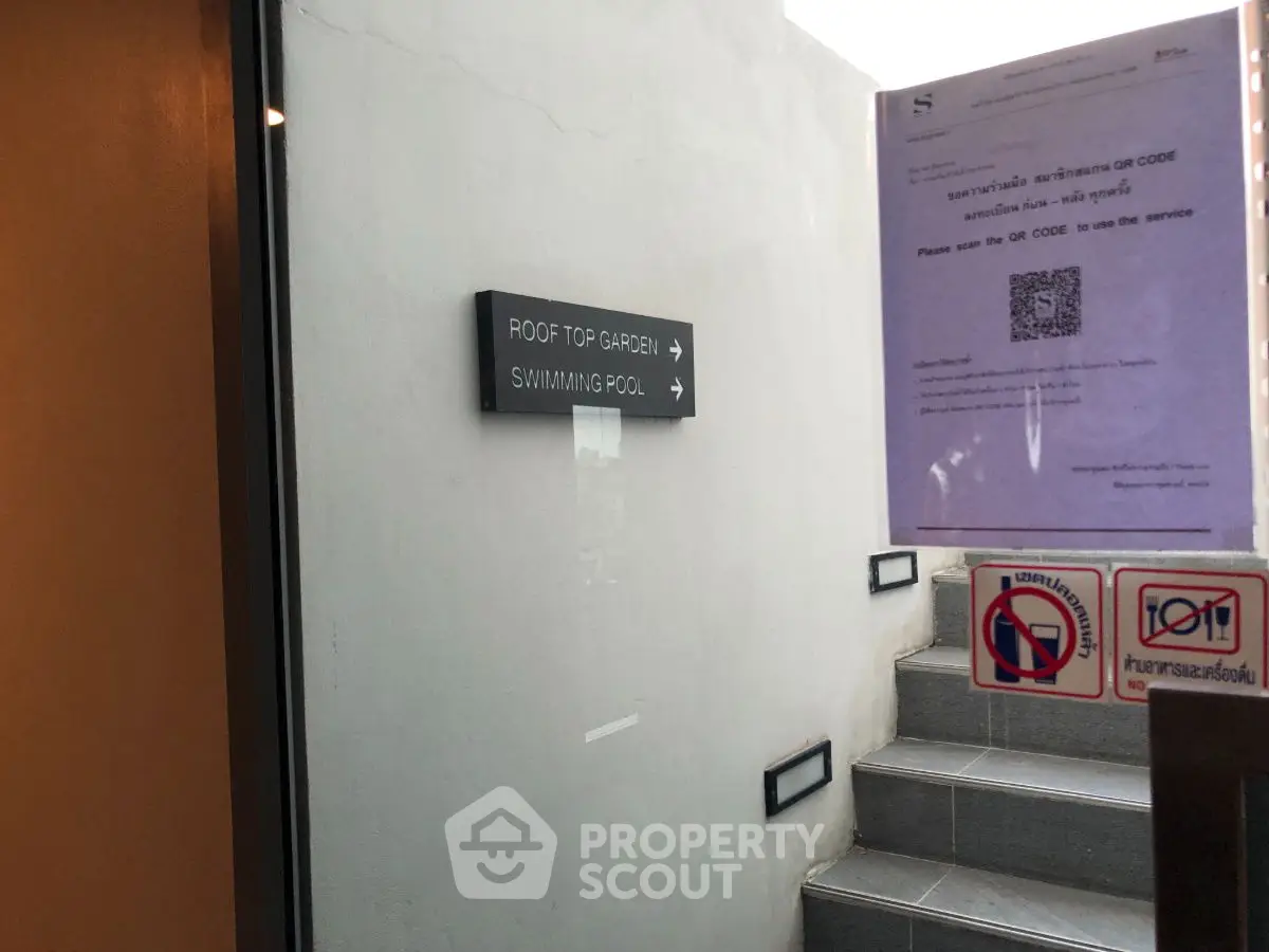 Entrance to rooftop garden and swimming pool with staircase and sign.