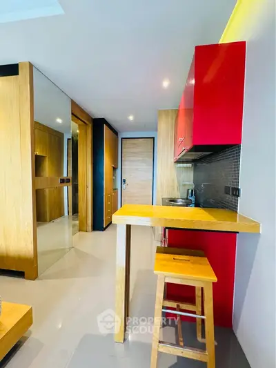 Modern kitchen with vibrant red cabinets and sleek wooden finishes