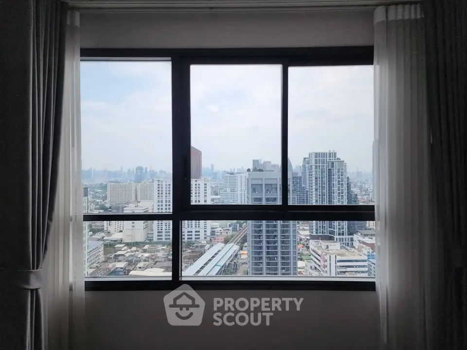 Stunning cityscape view from a high-rise apartment window, showcasing urban skyline and modern architecture.