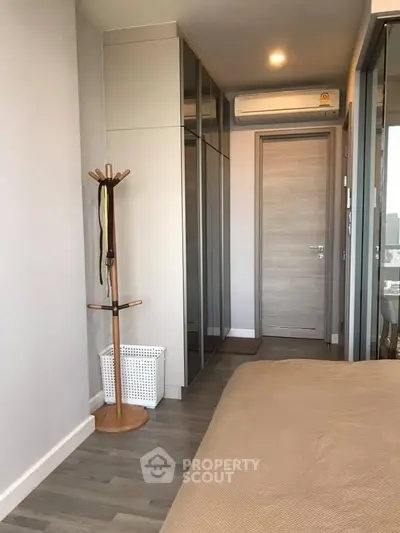Modern bedroom with sleek design, mirrored wardrobe, and wooden flooring for a cozy ambiance.