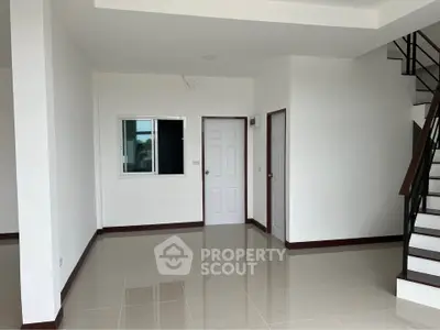 Spacious modern interior with sleek staircase and glossy tiled floors, perfect for contemporary living.