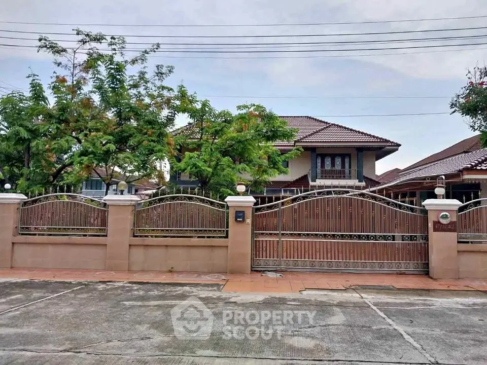 Charming suburban house with gated entrance and lush greenery, perfect for family living.