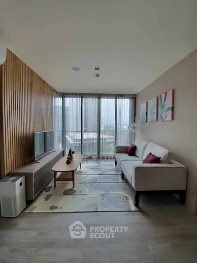 Modern living room with stylish decor and large windows offering natural light.