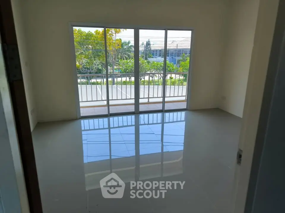 Spacious room with large windows and balcony overlooking greenery, perfect for natural light lovers.