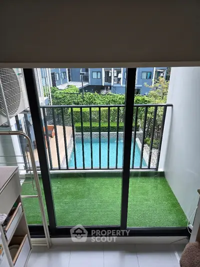 Charming apartment balcony with pool view and lush greenery, perfect for relaxation and leisure.