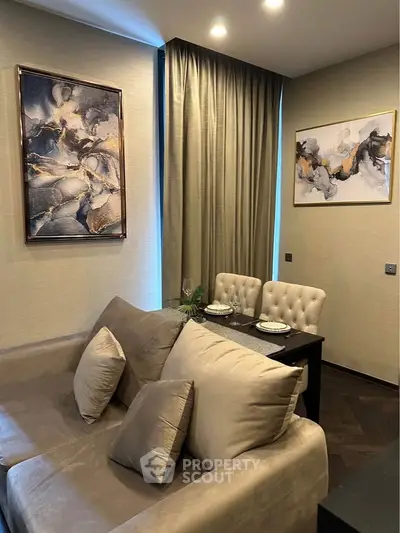 Elegant living room with modern art and cozy dining area, perfect for stylish urban living.