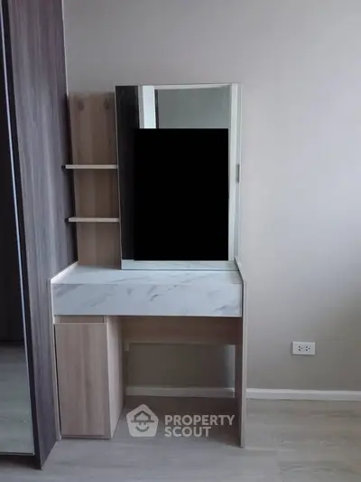Modern bedroom with sleek vanity and mirror, perfect for stylish living.