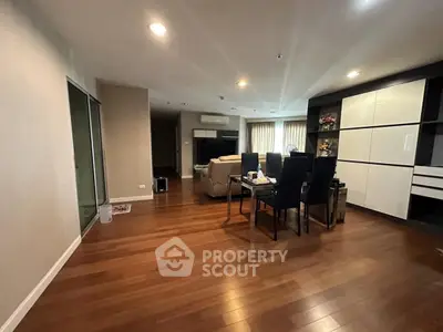 Spacious modern living room with elegant dining area and wooden flooring.