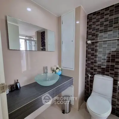 Modern bathroom with glass sink and stylish tile design