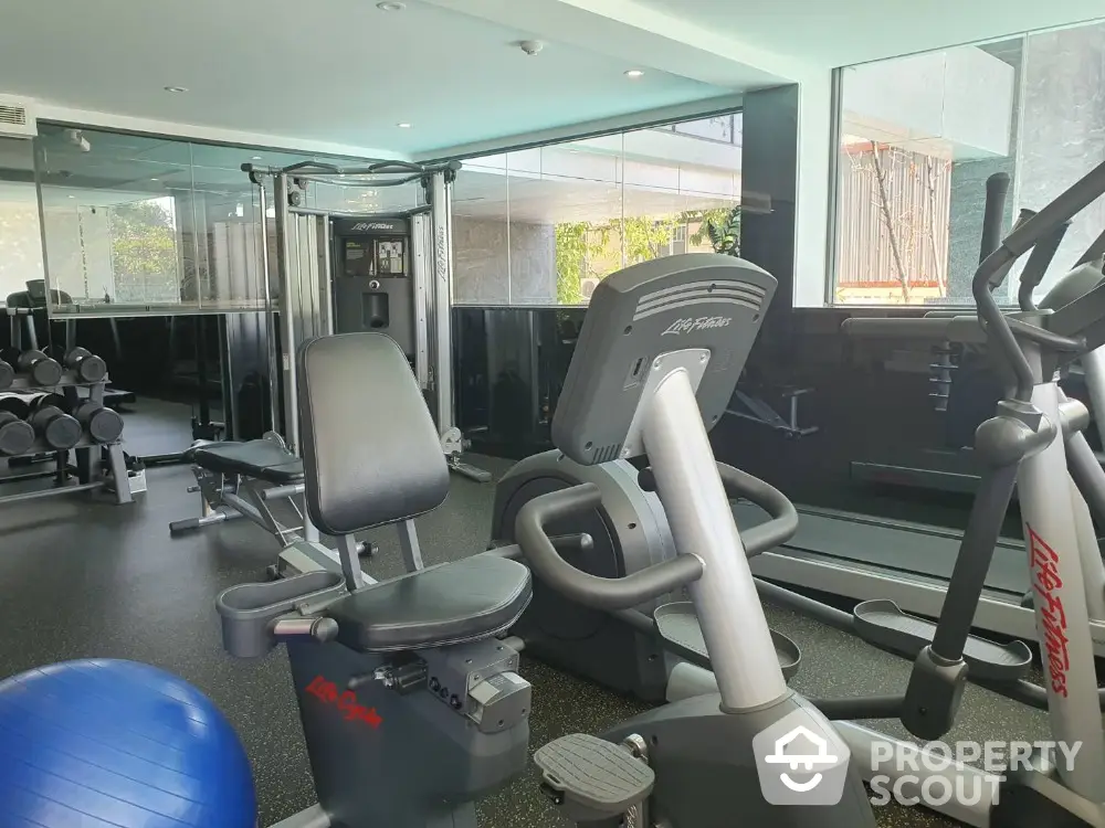 Modern gym with exercise equipment in a bright, spacious room