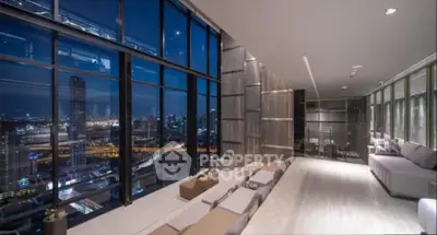 Luxurious high-rise living room with stunning cityscape view at night.