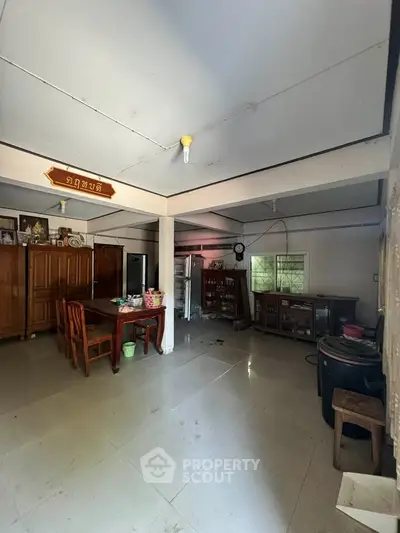 Spacious open-layout living area with dining table and traditional decor, perfect for family gatherings.