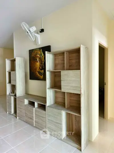 Modern interior with stylish wooden shelves and wall art in a bright living space.