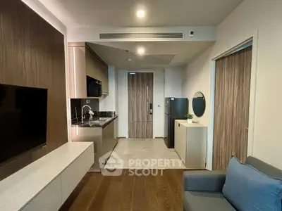Modern living room with sleek kitchen and stylish decor in a contemporary apartment.
