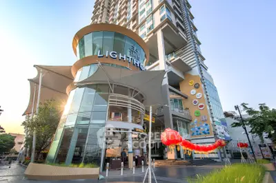 Modern high-rise building with unique architectural design and vibrant street view.